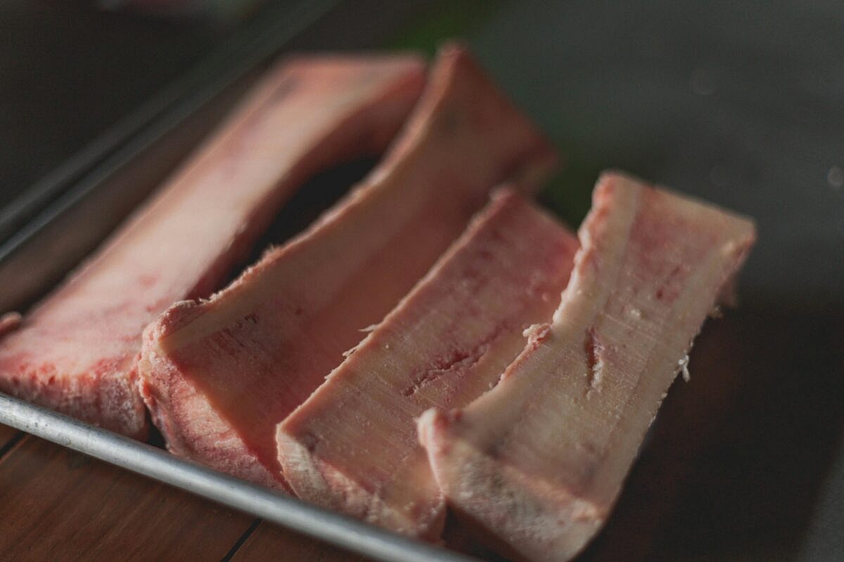 Close-up of four cooked bones on a tray, cooked bones are among the human foods toxic to dogs