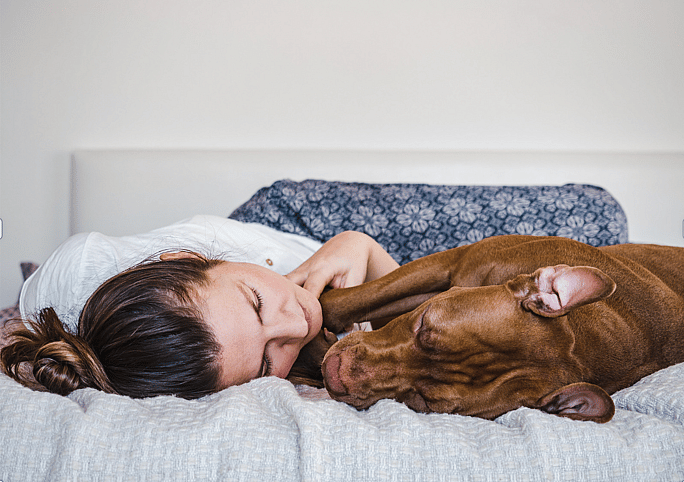 woman sleeping with dog