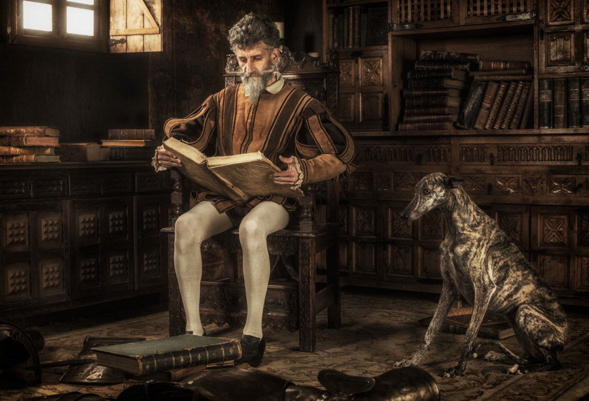 Literary Names for Dogs: historic photo of a man reading a book next to a greyhound